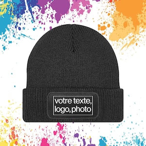Può includere: Un berretto nero con una toppa rettangolare sul davanti. La toppa riporta le parole "votre texte, logo, photo" in testo bianco. Lo sfondo presenta schizzi di vernice colorati.