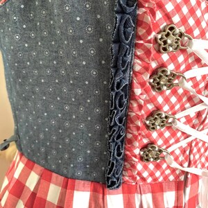 May include: A red and white gingham dress with a blue denim bodice and white lace-up detail. The bodice has a white polka dot pattern.