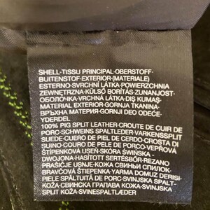 May include: A black fabric garment care label with white text. The label reads: SHELL-TISSU PRINCIPAL-OBERSTOFF-BUITENSTOF-EXTERIOR-(MATERIALE) ESTERNO-SVRCHN&Iacute; L&Aacute;TKA-POWIERZCHNIA ZEWNĘTRZNA-K&Uuml;LSŐ BOR&Iacute;T&Aacute;S-ZUNANJOST-ОБОЛОЧКА-VRCHN&Aacute; L&Aacute;TKA-DIŞ KUMAŞ-MATERIAL EXTERIOR-GORNJA TKANINA-ВРЪХНА МАТЕРИЯ-GORNJI DEO ODEĆE-YDERDEL 100% PIG SPLIT LEATHER-CROUTE DE CUIR DE PORC-SCHWEINS SPALTLEDER-VARKENSSPLIT SUEDE-CUERO DE PIEL DE CERDO-CROSTA DI SUINO-COURO DE PELE DE PORCO-VEPŘOV&Aacute; &Scaron;T&Iacute;PENKOV&Aacute; USEŇ-SK&Oacute;RA ŚWIŃSKA-DWOJONA-HAS&Iacute;TOTT SERT&Eacute;SBŐR-REZANO PRA&Scaron;IČJE USNJE-КОЖА СВИНЬИ СПИЛОК-BRAVČOV&Aacute; &Scaron;TIEPENKA-YARMA DOMUZ DERISI-PIELE SPĂLTUITĂ DE PORC-SVINJSKA SPALT-KOŽA-СВИНСКА ГРАПАВА КОЖА-SVINJSKA SPLIT KOŽA-SVINESPALTLAEDER.