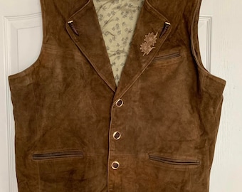 May include: A brown suede vest with a button closure and two pockets. The vest has a floral embroidery design on the front.