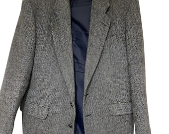 May include: A gray tweed blazer with a single button closure. The blazer has a classic fit and a subtle herringbone pattern.