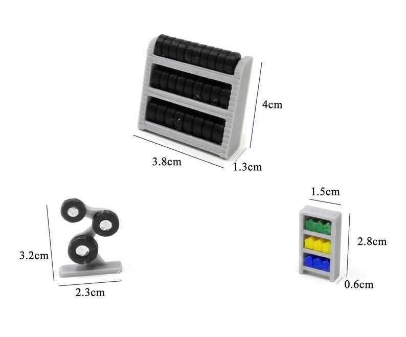 May include: Three miniature toy shelves for a dollhouse or miniature scene. The shelves are gray and have black tires on them. The shelves are 4 inches tall, 1.3 inches wide, and 3.8 inches long. The other shelf is 1.5 inches tall, 0.66 inches wide, and 2.8 inches long. The shelf has three shelves with green, yellow, and blue items on them. The other shelf is 3.2 inches tall, 2.3 inches wide, and has three black tires on it.