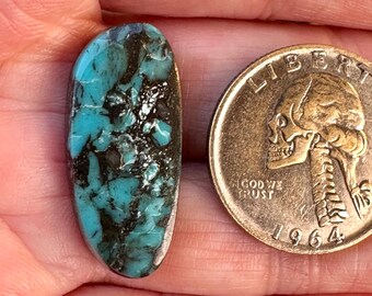 May include: A turquoise cabochon with a dark matrix, measuring approximately the size of a UK 20 pence coin.