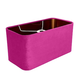 Può includere: Un paralume rettangolare rosa in tessuto di velluto.