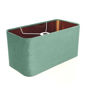 May include: A rectangular light green velvet lampshade with a white cord.