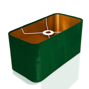 May include: A rectangular lampshade with a dark green velvet exterior and a copper interior. The shade has a white wire frame.