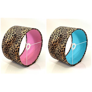 Può includere: Due paralumi con un design a stampa leopardata. Un paralume ha una fodera rosa e l'altro ha una fodera blu.