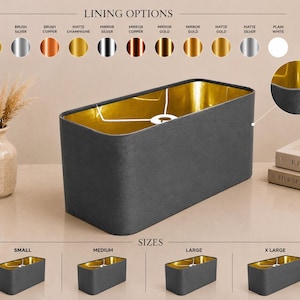 Op de afbeelding: Een rechthoekige lampenkap met een donkergrijze buitenkant en een reflecterende gouden binnenvoering. De afbeelding toont diverse voeringopties, waaronder geborsteld goud, zilver, koper, mat champagne, spiegelfinishes en effen wit, naast vier verschillende maten.