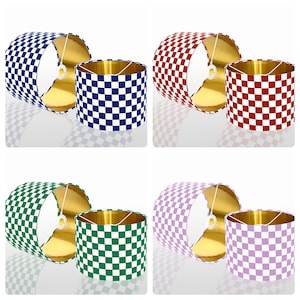 May include: Four lampshades with a checkered pattern in different colors. The lampshades are blue, red, green, and purple.