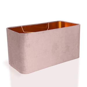May include: A rectangular lampshade with a soft, blush pink velvet exterior. The interior is a warm, metallic gold color. The lampshade has rounded corners and a simple, elegant design, suitable for various home decor styles.