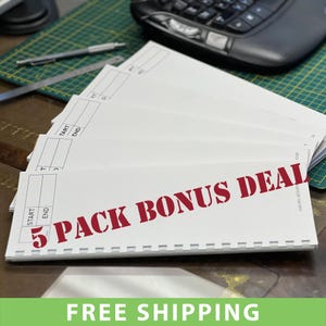 May include: A collection of white paper documents, fanned out on a wooden surface. The text "5 PACK BONUS DEAL" is printed in red across the documents. A green cutting mat and a computer mouse are in the background. The documents have blue and black text.