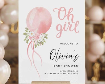 May include: A pink and white baby shower welcome sign with a watercolor balloon and floral accents. The sign reads "Oh girl, Welcome to Olivia's Baby Shower, April 17th, 2024, We are so glad you are here."
