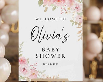 May include: A white sign with pink floral watercolor designs and the text "Welcome to Olivia's Baby Shower June 6, 2024".