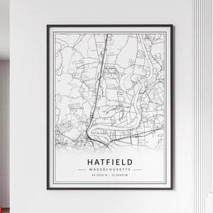 May include: Black and white line art map print of Hatfield, Massachusetts. The map shows the town's streets, roads, and waterways. The print includes the town's name, state, and coordinates: 42.3733°N - 72.5963°W.