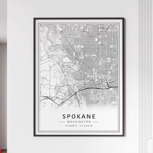 May include: Black and white line art map of Spokane, Washington. The map shows the city streets and includes the city name and coordinates: 47.6580°N - 117.4235°W.
