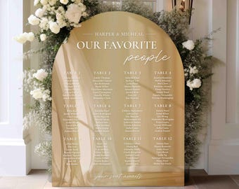 Könnte beinhalten: Ein goldfarbener, bogenförmiger Sitzplan mit weißem Text. Der Text lautet "Harper & Micheal Our Favorite People" und listet die Namen der Gäste an jedem Tisch auf. Der Plan ist mit einem dezenten, verschwommenen Bild von weißem Stoff verziert.