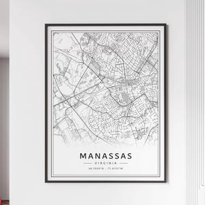 May include: A framed monochrome map print of Manassas, Virginia, featuring a detailed street plan. The city's name and state are displayed in a modern font at the bottom, along with the coordinates 38.7509°N - 77.4753°W.
