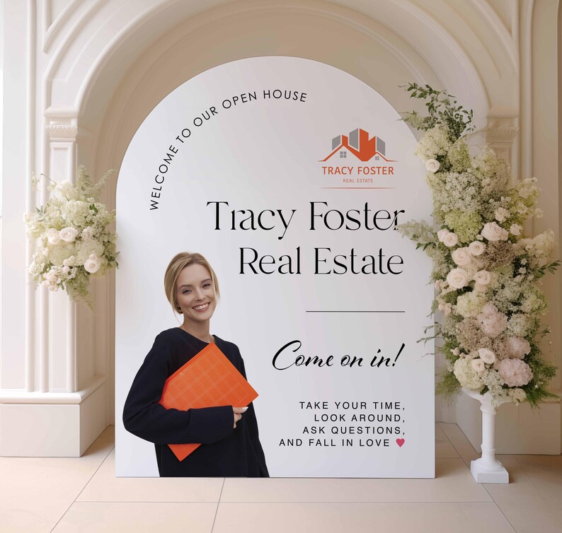 Może przedstawiać: Biały szyld z napisem "WELCOME TO OUR OPEN HOUSE" i "Tracy Foster Real Estate". Kobieta w czarnym topie trzyma pomarańczową teczkę. Na szyldzie napis "Come on in!"