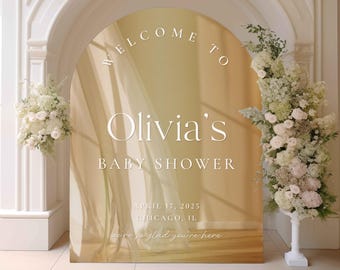 May include: A gold archway with a white text overlay that reads "Welcome to Olivia's Baby Shower April 17, 2025 Chicago, IL we're so glad you're here".