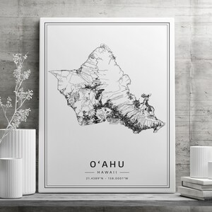 May include: Black and white line art print of the island of Oahu, Hawaii. The print includes the text "O'AHU" and "HAWAII" with the coordinates "21.4389&deg;N - 158.0001&deg;W".