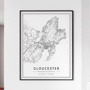 May include: Black and white line art map of Gloucester, Massachusetts. The map shows the city's streets and coastline. The text "GLOUCESTER - MASSACHUSETTS - 42.6159°N - 70.6620°W" is printed below the map.