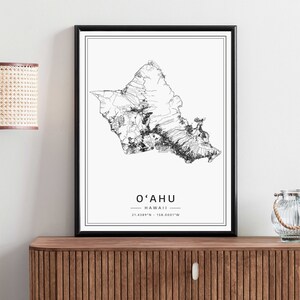 May include: Black and white line art print of the island of Oahu, Hawaii. The print includes the name "O'ahu" and the coordinates "21.4389&deg;N - 158.0001&deg;W".