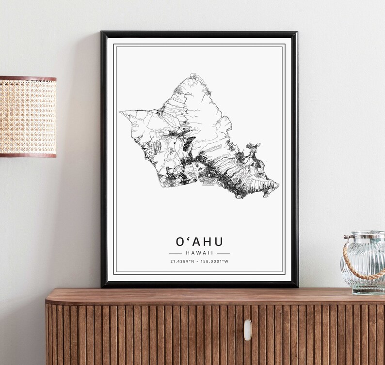 May include: Black and white line art print of the island of Oahu, Hawaii. The print includes the name "O'ahu" and the coordinates "21.4389&deg;N - 158.0001&deg;W".