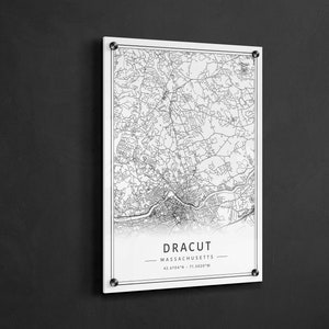 May include: A black and white map print of Dracut, Massachusetts. The map shows the city's streets and landmarks. The text "Dracut, Massachusetts" and the coordinates "42.6704&deg;N - 71.3020&deg;W" are printed below the map.