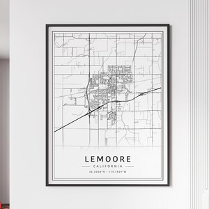 May include: A framed black and white map print of Lemoore, California. The map details the city's layout with roads and buildings. The text "LEMOORE CALIFORNIA" is centered at the bottom, with coordinates 36.3008°N - 119.7829°W.