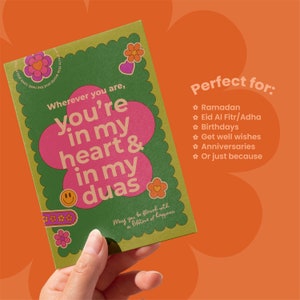 May include: A greeting card with a green scalloped border and a large pink flower design. The card features the text "Wherever you are, you're in my heart & in my duas." Additional floral and smiley face graphics are included.