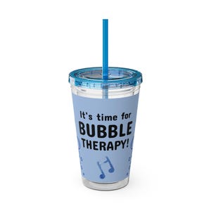 May include: A clear plastic tumbler with a blue lid and straw. The tumbler has a blue background with the text "It's time for BUBBLE THERAPY!" and a musical note graphic.