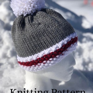 May include: Grey knitted hat with a white pom pom and a red and white stripe around the brim. Knitting Pattern.