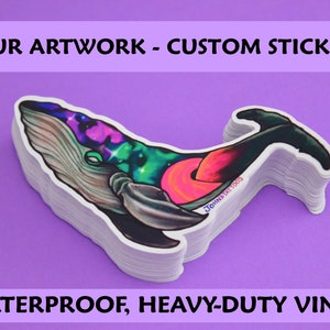 May include: A stack of waterproof, heavy-duty vinyl stickers featuring a colourful whale with a galaxy design. The stickers are printed with the text "JOHNDTAT TOOS".