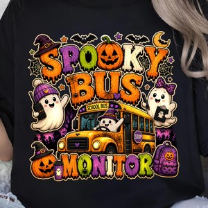Puede incluir: Una camiseta negra con un gráfico colorido y el texto "SPOOKY BUS MONITOR". El diseño incluye un autobús escolar amarillo conducido por un fantasma, otros dos fantasmas, dos calabazas de Halloween, una mochila morada, murciélagos y telarañas.