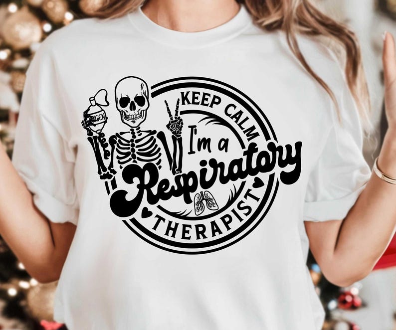 May include: White t-shirt with a black graphic featuring a skeleton holding an oxygen tank and making a peace sign. The text reads "Keep Calm I'm a Respiratory Therapist" in a circular design with a heart and lungs.