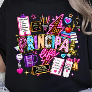May include: A black t-shirt featuring a colourful graphic with the text PRINCIPAL life. The design includes a checklist, a mug labelled PRINCIPAL FUEL, a leopard print lightning bolt, a stack of books, a red apple, a bell, and school-themed icons.