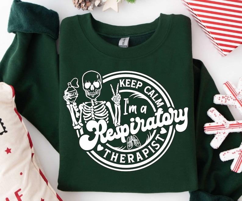 May include: Dark green sweatshirt with a white graphic of a skeleton holding an oxygen tank and making a peace sign. The text reads "Keep Calm I'm a Respiratory Therapist."