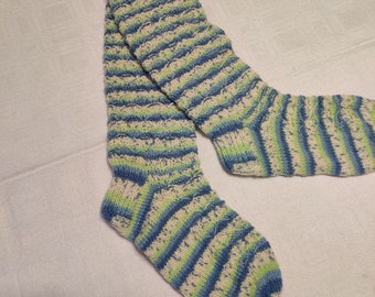 May include: A pair of striped socks in shades of blue, green, and white. The socks are knitted and have a textured appearance.