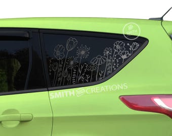Peut inclure: Une voiture vert lime avec un motif floral blanc sur la vitre arrière. Le motif comprend des fleurs, des feuilles et des tiges. La voiture a un autocollant blanc sur le côté qui dit "SMITH CREATIONS".