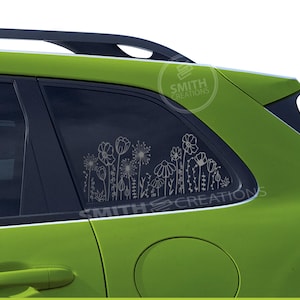 May include: A lime green car with a floral decal on the rear window. The decal features a collection of stylized flowers and foliage in a white outline design. The text "SMITH CREATIONS" is also visible.