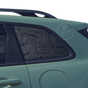 May include: A green SUV with a black window tint and a custom window graphic of a topographic map design. The graphic is on the rear passenger window and has a white outline. The vehicle has a black roof rack and the text "SMITH CREATIONS" is visible on the side of the vehicle.