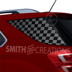 May include: Red SUV with a black and white checkered pattern applied to the rear passenger window. The text "SMITH CREATIONS" is visible on the vehicle's side and rear window. A logo is also visible.