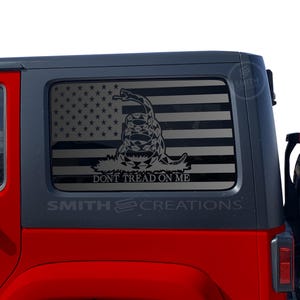 May include: A red Jeep Wrangler with a black and white American flag decal on the rear window. The decal features a snake with the words "Don't Tread On Me".