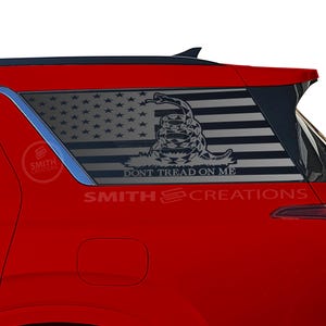 May include: A red SUV with a black and white American flag and a snake with the text "Don't Tread On Me" on the rear window.