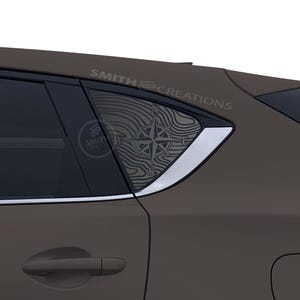 May include: A brown vehicle with a compass design on the rear window. The compass is set against a topographic map pattern. The text "SMITH CREATIONS" is visible on the window and above the window.