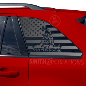 May include: A red car with a black and white American flag and a snake with the words "Don't Tread On Me" on the rear window.