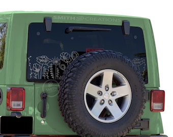 May include: A green Jeep SUV with a spare tire and a floral decal on the rear window. The decal features white line art of various flowers and foliage. The text "SMITH CREATIONS" is visible on the window.