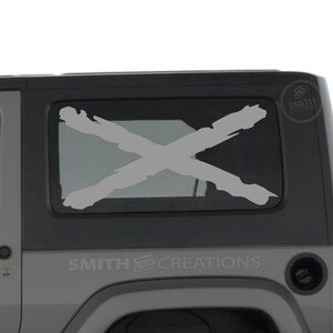 May include: A light gray Jeep with a large gray X decal on the rear window. The text "SMITH CREATIONS" is visible on the vehicle. A spare tire is mounted on the back.