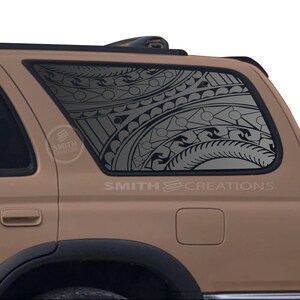 May include: A tan SUV with a decorative window decal featuring a black and gray tribal design. The decal covers the rear passenger window. The text "SMITH CREATIONS" is visible on the vehicle.