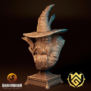 May include: A detailed bust of a wizard with a long beard, round glasses, and a tall hat adorned with feathers. The wizard is holding a quill and is mounted on a decorative base. The bust is a neutral color and has the Dragonborn Resin Prints logo.